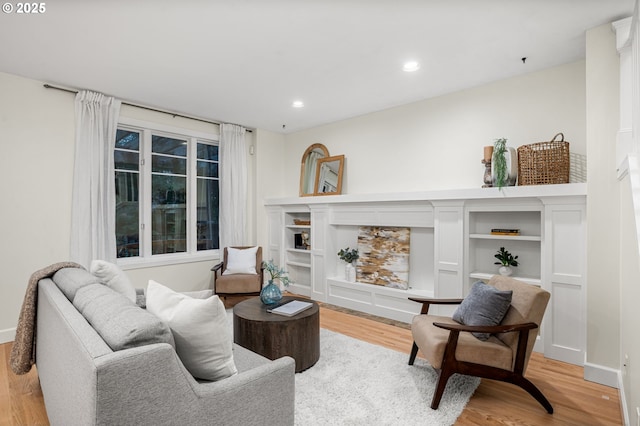 living room with a fireplace, recessed lighting, baseboards, and light wood finished floors