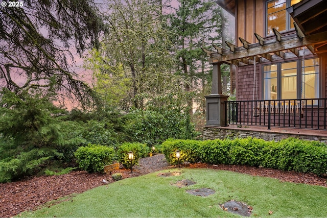 yard at dusk featuring a pergola