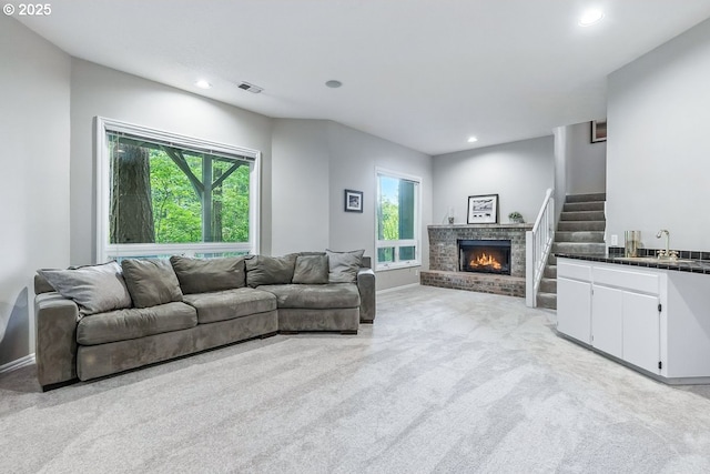 10585 SW 161st Ct, Beaverton, OR 97007 - living area with light carpet, healthy amount of natural light, recessed lighting, a brick fireplace, and stairs