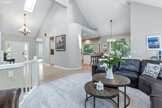 10585 SW 161st Ct, Beaverton, OR 97007 - living area featuring a chandelier, high vaulted ceiling, light wood finished floors, healthy amount of natural light, and a skylight