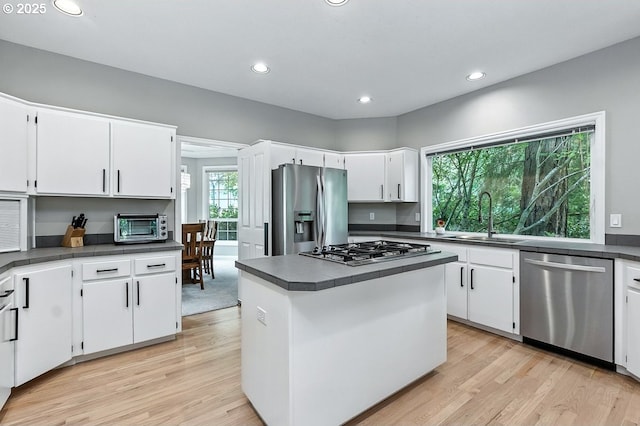 10585 SW 161st Ct, Beaverton, OR 97007 - kitchen with appliances with stainless steel finishes, light wood finished floors, white cabinetry, recessed lighting, and dark countertops