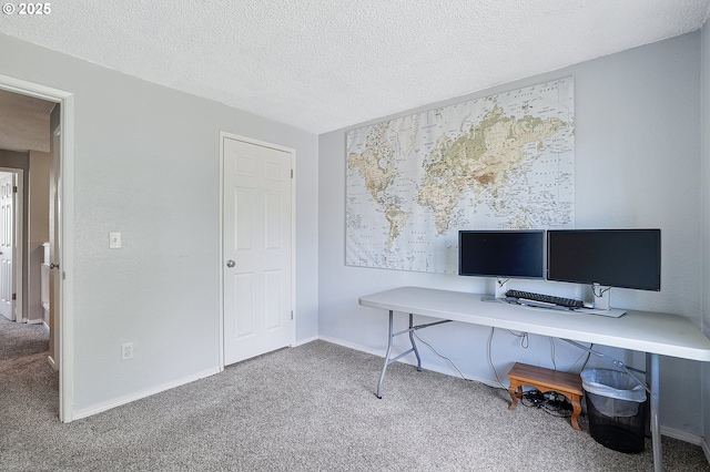 carpeted office space with a textured ceiling and baseboards