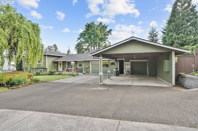 view of front of property featuring fence, a chimney, a shingled roof, an attached garage, and driveway