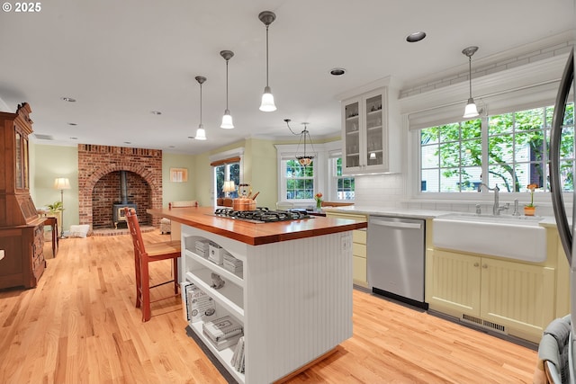 kitchen featuring butcher block countertops, appliances with stainless steel finishes, plenty of natural light, and a sink