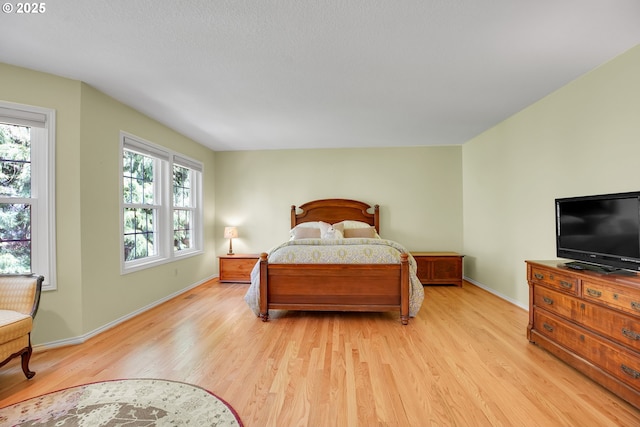 bedroom featuring light wood-style floors and baseboards