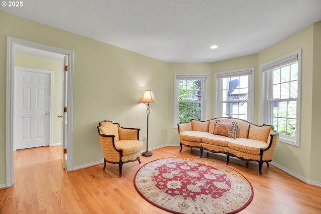 sitting room featuring recessed lighting, baseboards, light wood-style flooring, and a textured ceiling