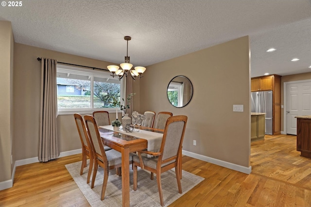 dining room with a chandelier, a textured ceiling, recessed lighting, baseboards, and light wood-type flooring