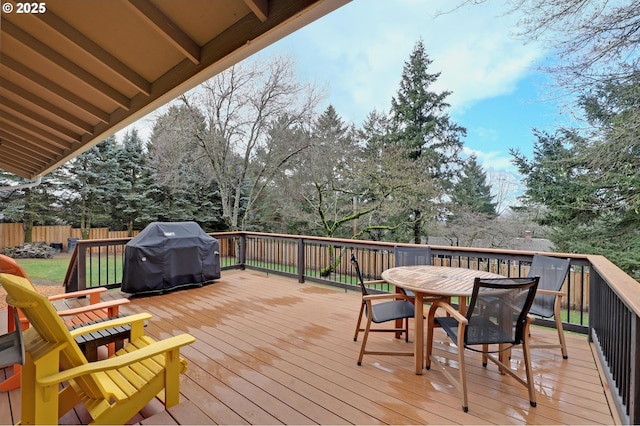 wooden terrace featuring outdoor dining space, fence, and area for grilling