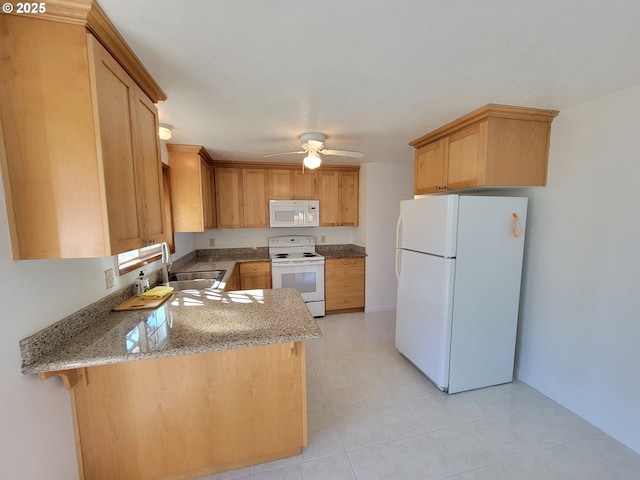 kitchen featuring ceiling fan, a peninsula, white appliances, a sink, and light stone countertops