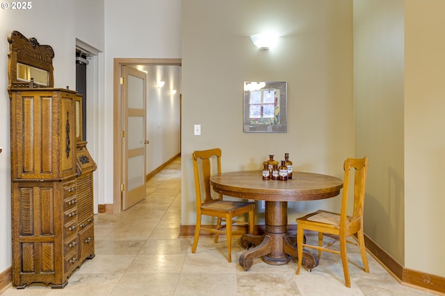 dining space featuring light tile patterned floors and baseboards