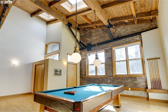 rec room with a towering ceiling, light wood-style flooring, and beam ceiling