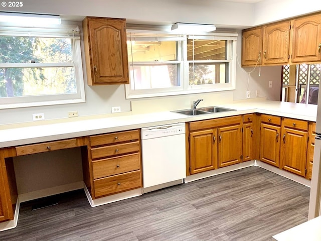 kitchen with sink, built in desk, dark hardwood / wood-style floors, dishwasher, and a healthy amount of sunlight