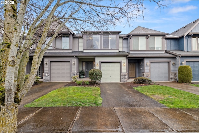 townhome / multi-family property featuring stone siding, an attached garage, and driveway