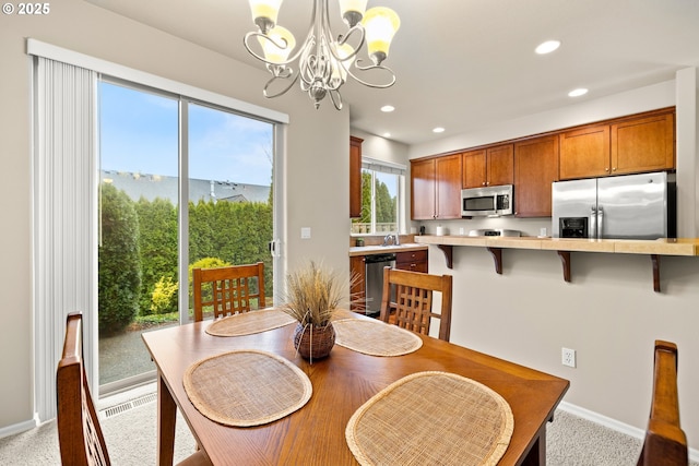 dining space with an inviting chandelier, baseboards, and recessed lighting