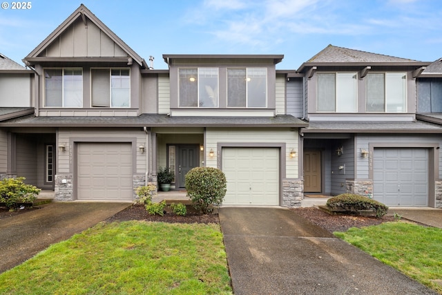 townhome / multi-family property with a garage, stone siding, driveway, and board and batten siding