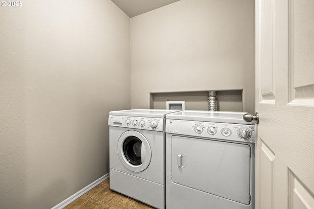 laundry room featuring laundry area, light tile patterned floors, baseboards, and separate washer and dryer