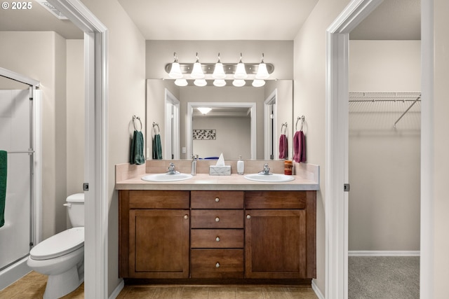 bathroom with double vanity, a stall shower, and a sink