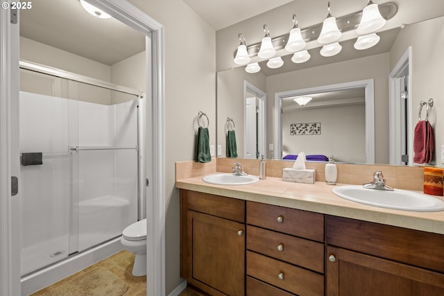 full bath featuring double vanity, a stall shower, a sink, and toilet
