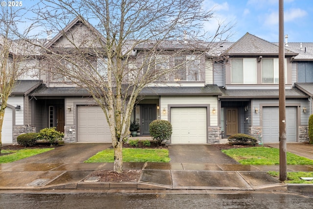 multi unit property with stone siding, roof with shingles, and driveway