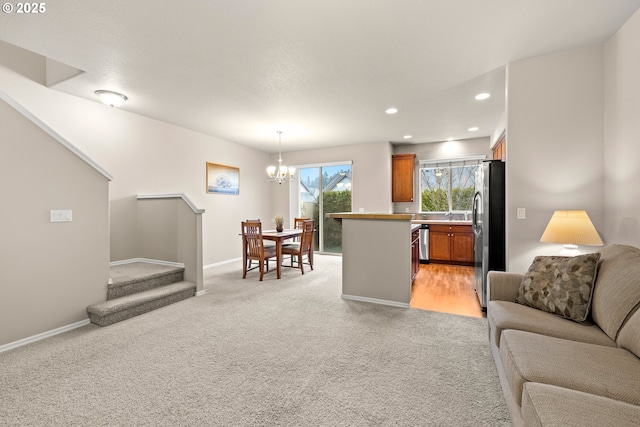 living area with a chandelier, recessed lighting, light colored carpet, baseboards, and stairway
