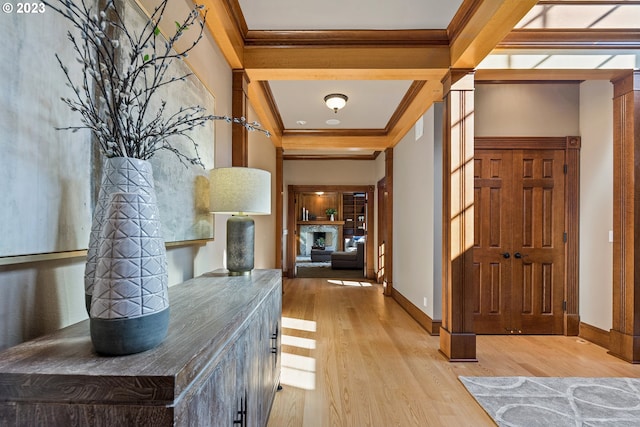 foyer entrance featuring crown molding, light wood-style floors, and baseboards