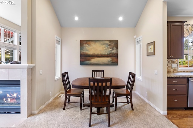 dining space with recessed lighting, baseboards, and a tile fireplace