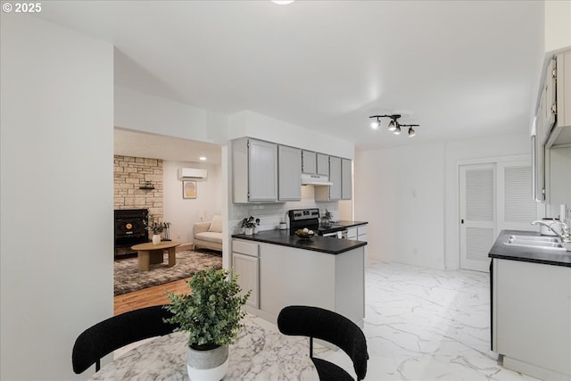 3434 Memorial Park Dr, Longview, WA 98632 - kitchen with stainless steel electric range oven, a wall mounted air conditioner, dark countertops, light marble finish flooring, and under cabinet range hood