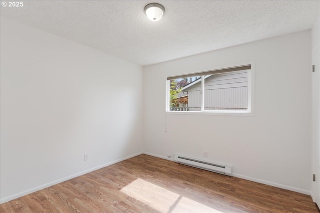 3434 Memorial Park Dr, Longview, WA 98632 - empty room featuring a baseboard radiator, wood finished floors, and a textured ceiling