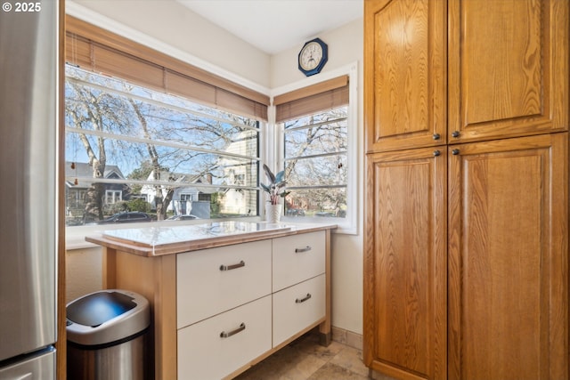 interior space with baseboards, light countertops, freestanding refrigerator, and white cabinets