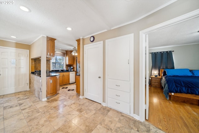 kitchen with brown cabinets, dark countertops, open floor plan, white dishwasher, and a sink