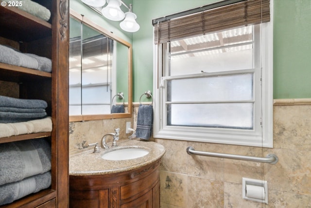 bathroom with a wainscoted wall, tile walls, and vanity