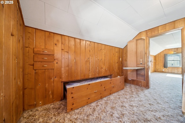 bonus room featuring vaulted ceiling, carpet, and wooden walls