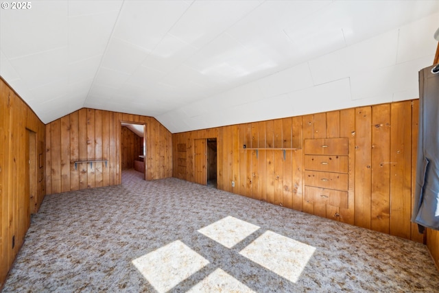 bonus room with carpet, vaulted ceiling, and wooden walls