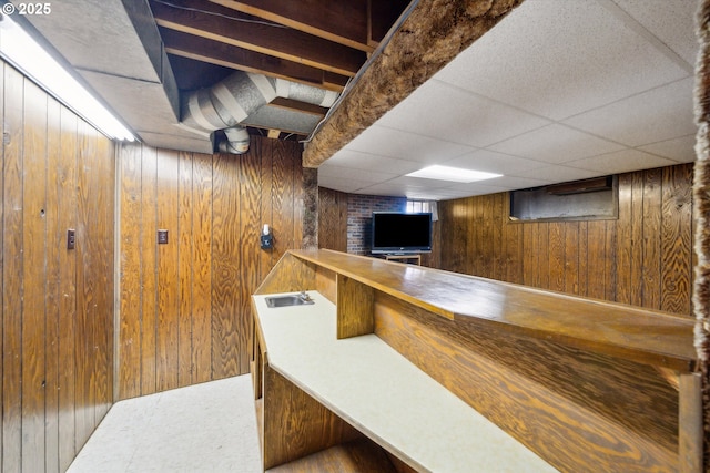 bar with a paneled ceiling, wooden walls, and a bar