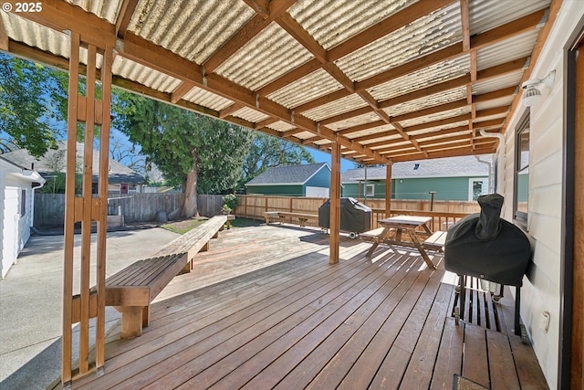 wooden deck with a fenced backyard and a grill