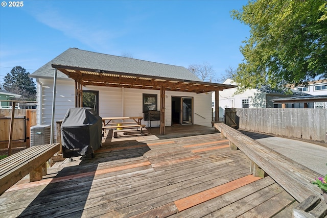 wooden terrace with fence, grilling area, and cooling unit