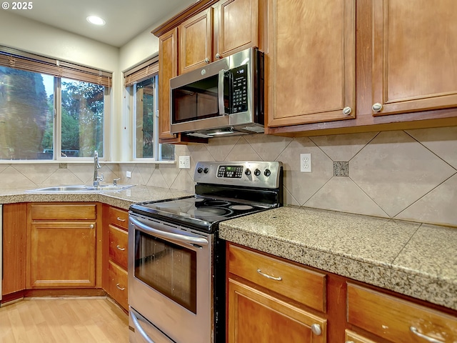 18840 SW Westland Ln, Beaverton, OR 97003 - kitchen with stainless steel appliances, brown cabinetry, backsplash, tile counters, and recessed lighting