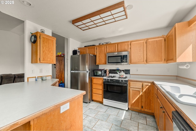 1232 E Fourth Ave, Sutherlin, OR 97479 - kitchen featuring appliances with stainless steel finishes, light countertops, and light tile patterned flooring