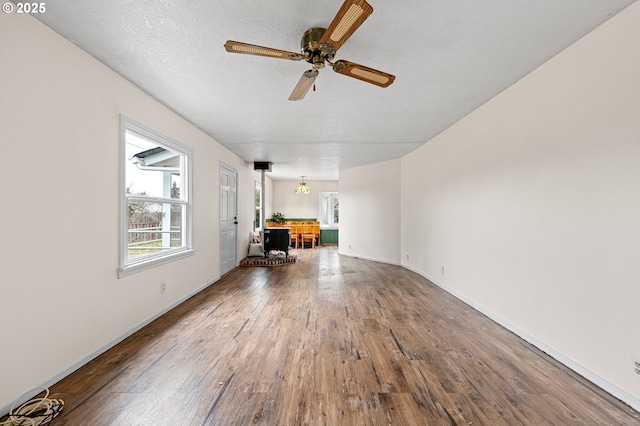 unfurnished living room featuring ceiling fan, hardwood / wood-style flooring, and a textured ceiling