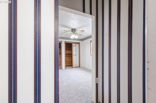 corridor featuring carpet floors and a textured ceiling