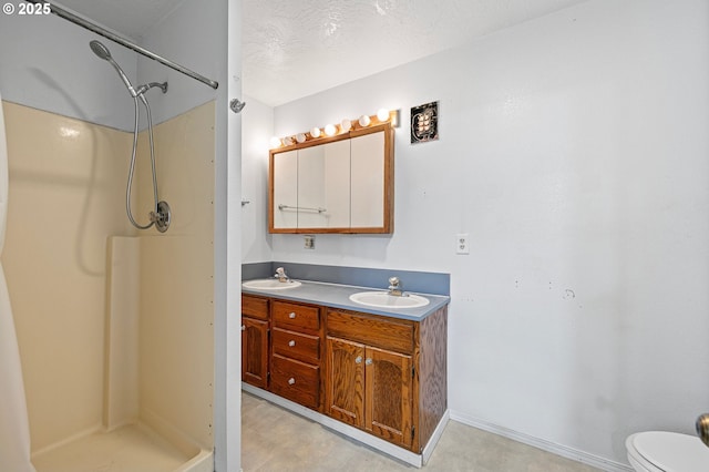 bathroom featuring vanity, toilet, a textured ceiling, and walk in shower