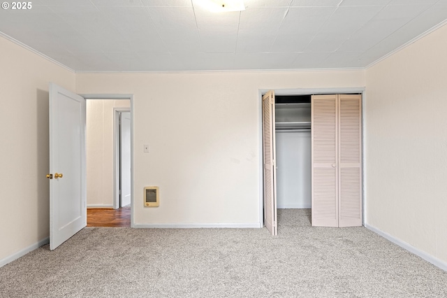 unfurnished bedroom featuring carpet floors, ornamental molding, and a closet