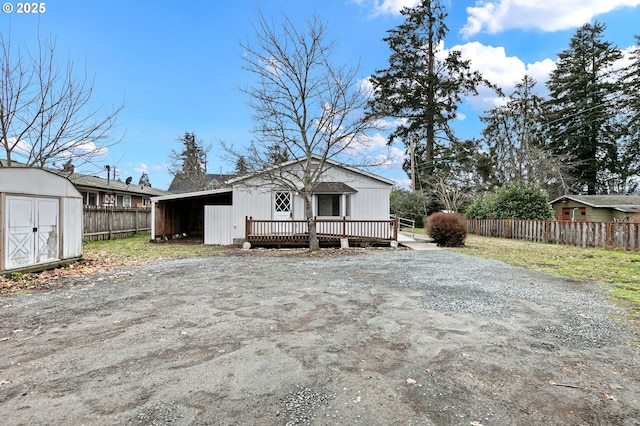 view of front of property with a wooden deck, a carport, and a shed