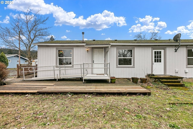 rear view of property with a yard and a deck