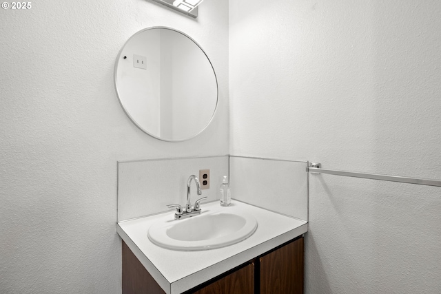 bathroom featuring vanity and a textured wall