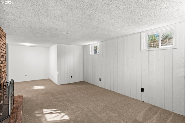 basement with carpet flooring, a brick fireplace, a textured ceiling, and wooden walls