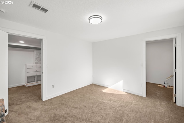 unfurnished bedroom featuring visible vents, carpet floors, and baseboards