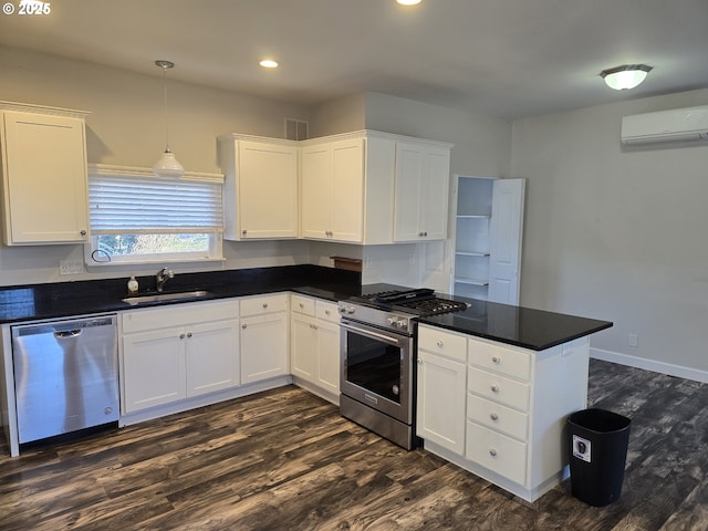 kitchen featuring sink, a wall unit AC, stainless steel appliances, and white cabinets