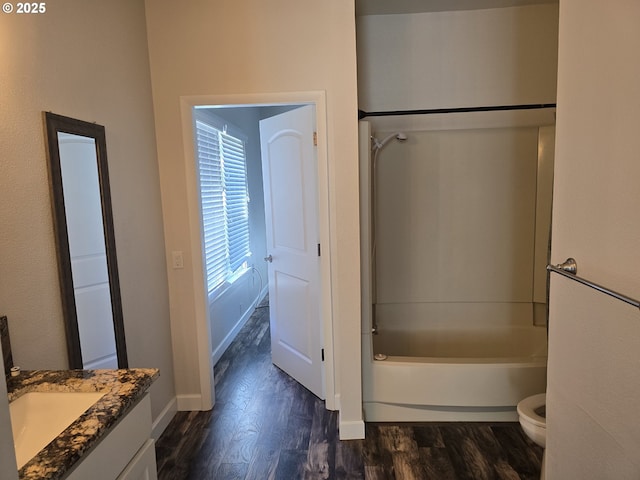 full bathroom with hardwood / wood-style flooring, shower / tub combination, vanity, and toilet