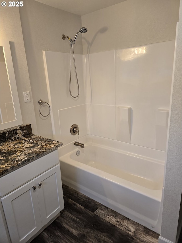 bathroom with hardwood / wood-style flooring, vanity, and tub / shower combination